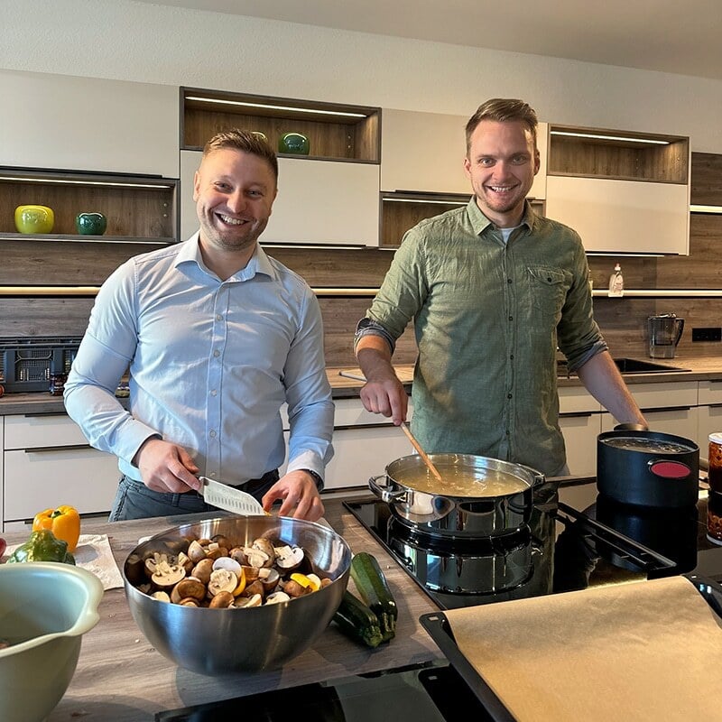 Portrait von Dimitri und Tim aus dem ecogreen Team beim Kochen